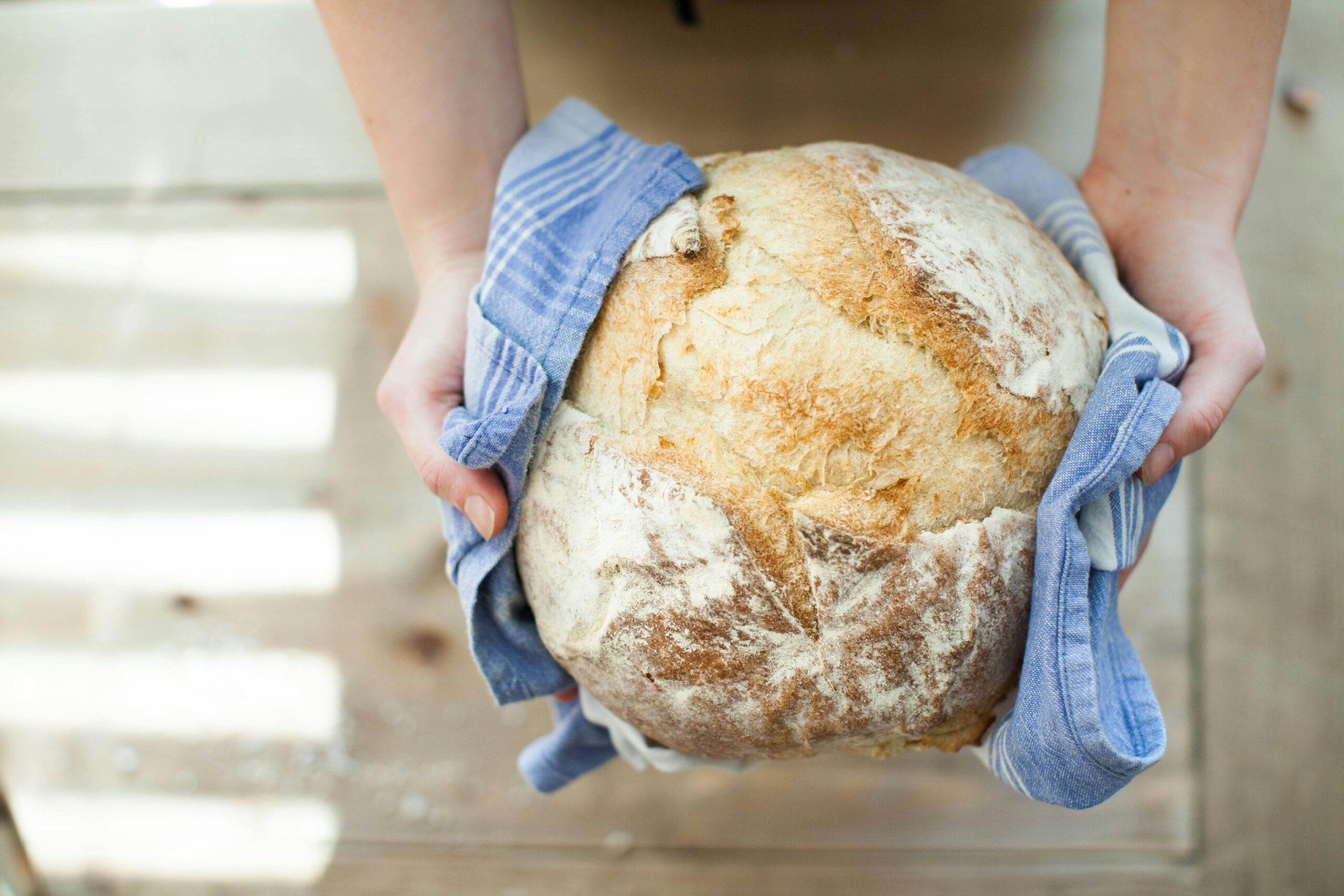 Artisan baker arranging fresh bread in a bakery display in Vancouver