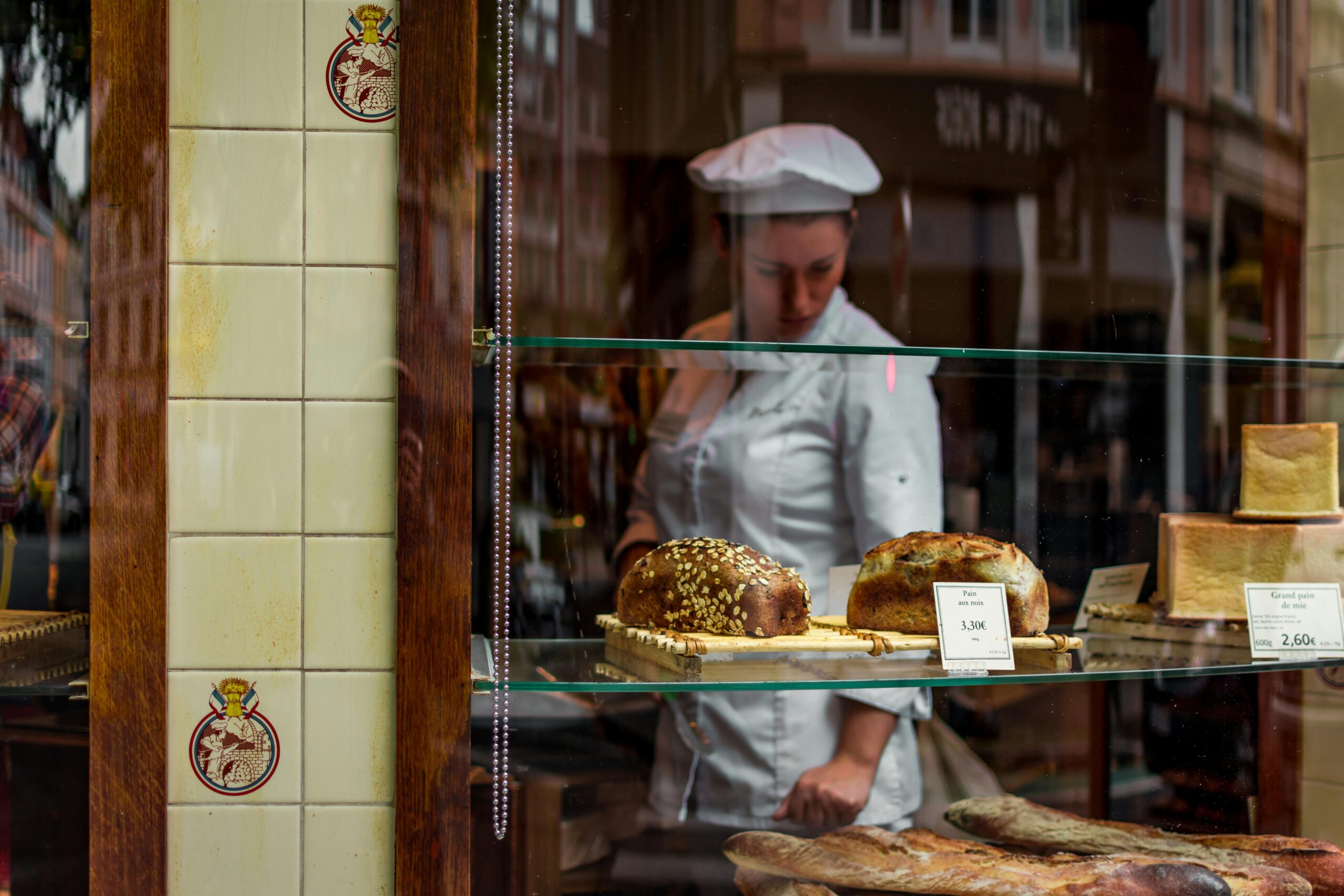 Baker placing freshly baked bread in a display case